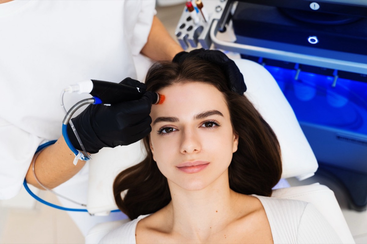 Practitioner performing a HydraFacial treatment on a patient's forehead