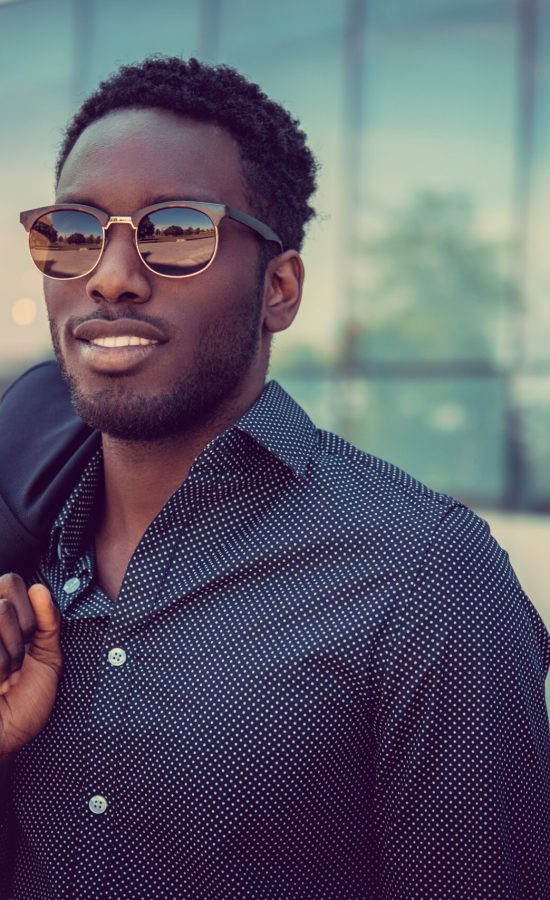 Casual african american male posing near modern building.